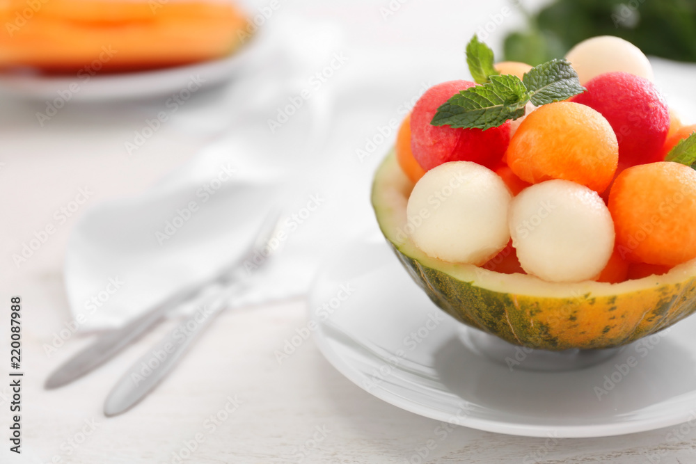 Bowl with fresh melon and watermelon balls on light table Bowl with fresh melon and watermelon balls on light table