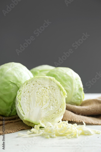 Fotografía Whole and sliced cabbage on white table