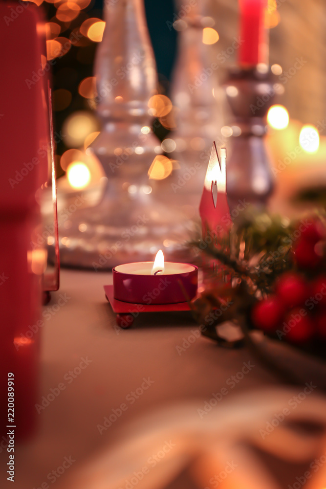 Burning candle on with Christmas decoration on table