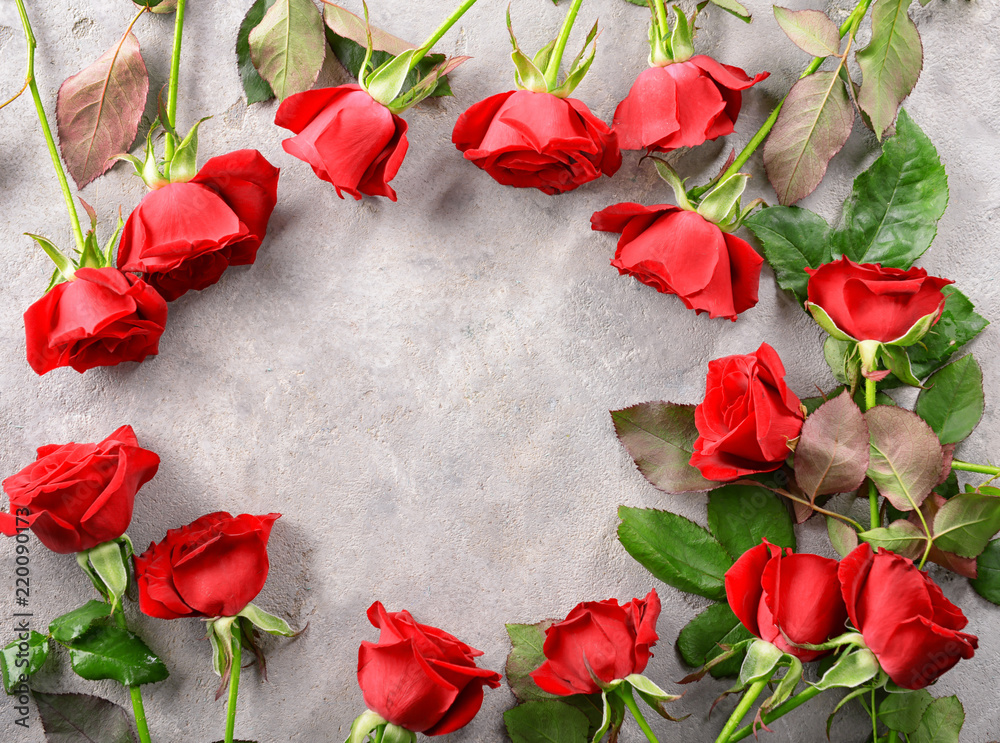 Frame made of beautiful red roses on grey background