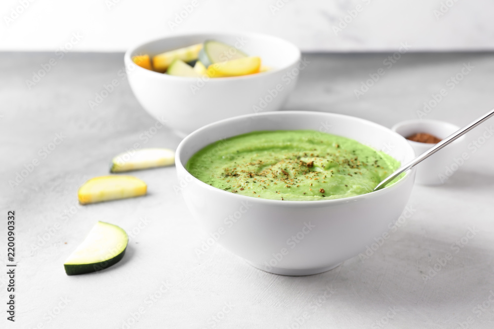 Tasty zucchini soup in bowl on light table Tasty zucchini soup in bowl on light table