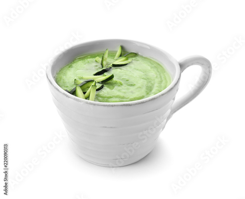 Tasty zucchini soup in cup on white background