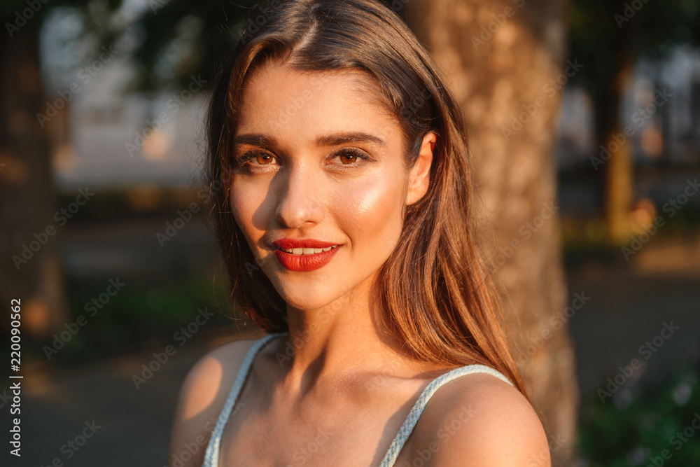 Cheerful woman walking outdoors while looking camera. Cheerful woman walking outdoors while looking camera.