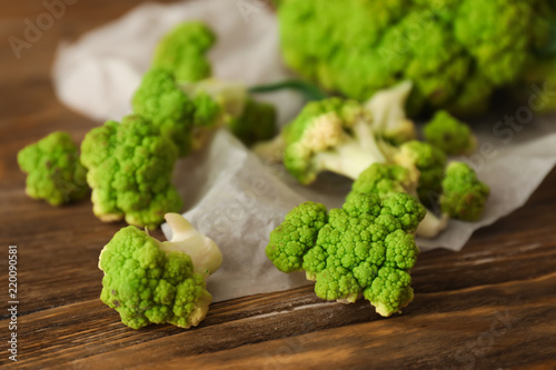 Green cauliflower cabbage on wooden table, closeup