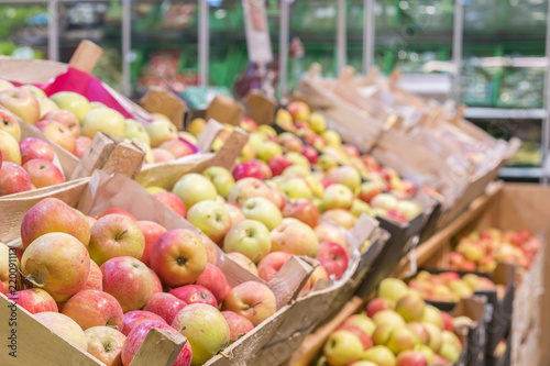 Fresh red apples in a tray in supermarket. Apples in farmer market. Boxes with fresh apples in a grocery store.