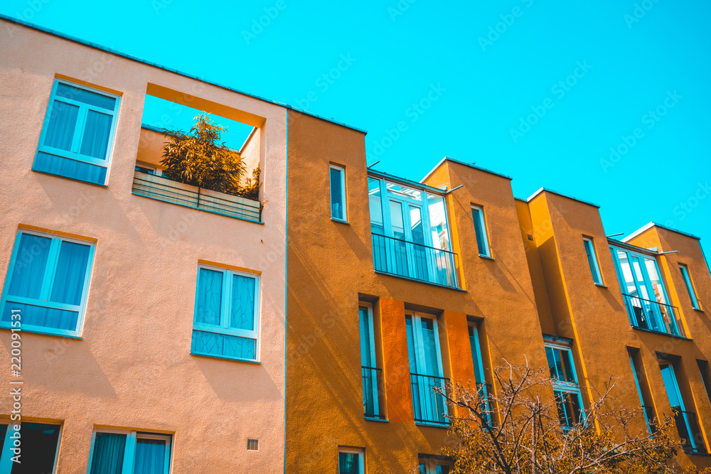 real estate picture of modern townhouses with pink and orange facade