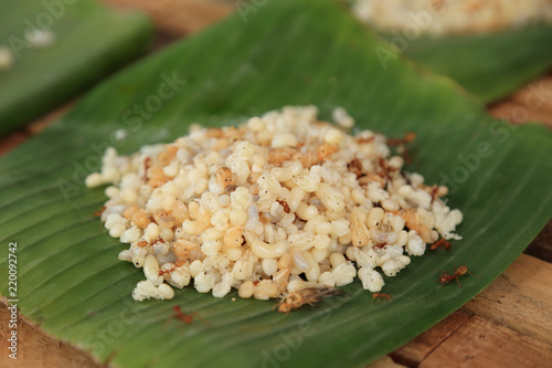 Pile of ant eggs with larva and weaver ants on green banana leaf. Delicious asian local food.