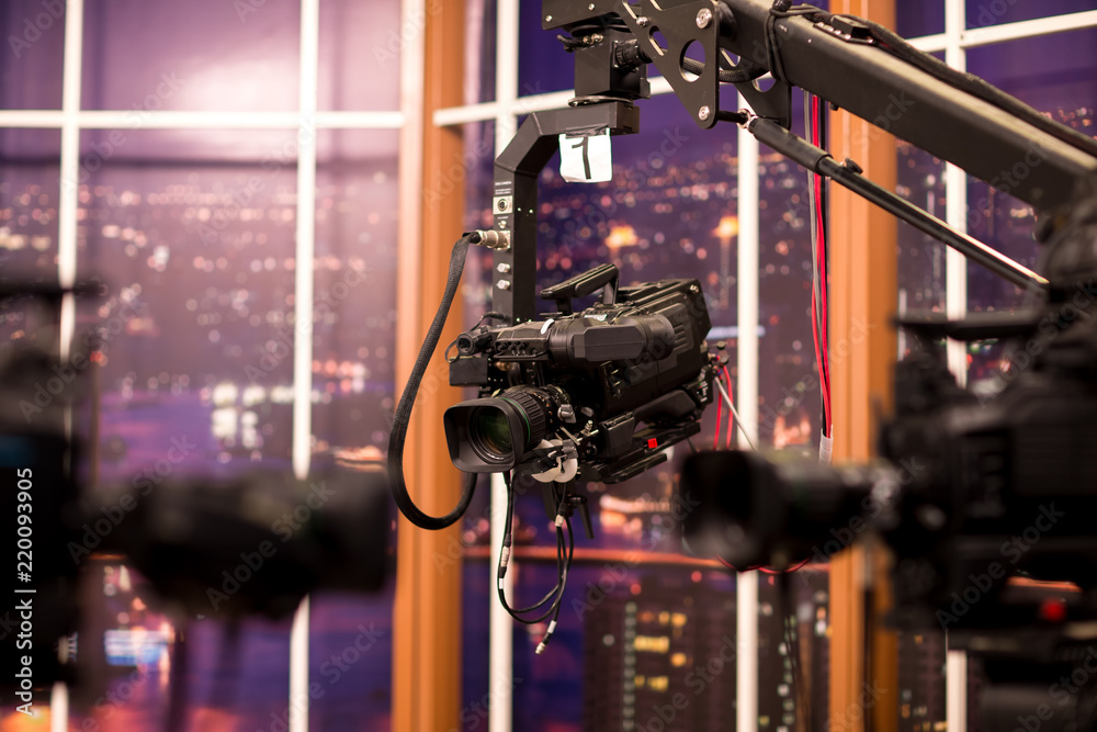 Camera in studio broadcasting news.