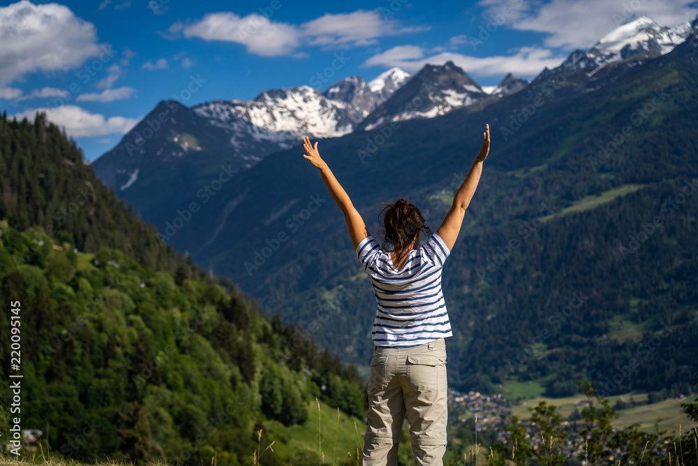 Female traveler admiring views of Swiss Alps in Val de Bagnes area, Switzerland.