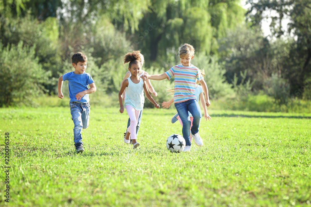 Cute little children playing football outdoors Cute little children playing football outdoors
