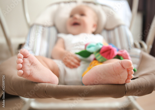 Canvas Print Cute baby sitting in rocker at home