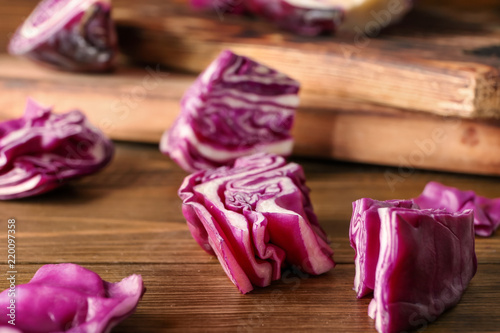 Cut red cabbage on wooden table, closeup