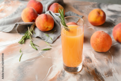 Peach juice in glass on color table