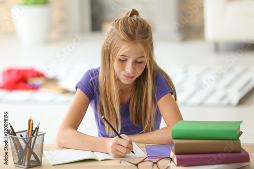 Cute schoolgirl doing homew...