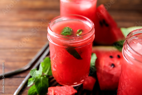 Jar with fresh watermelon smoothie on table