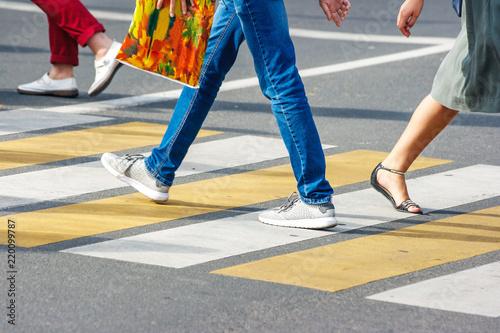  legs of people crossing the pedestrian crossing in the busy street