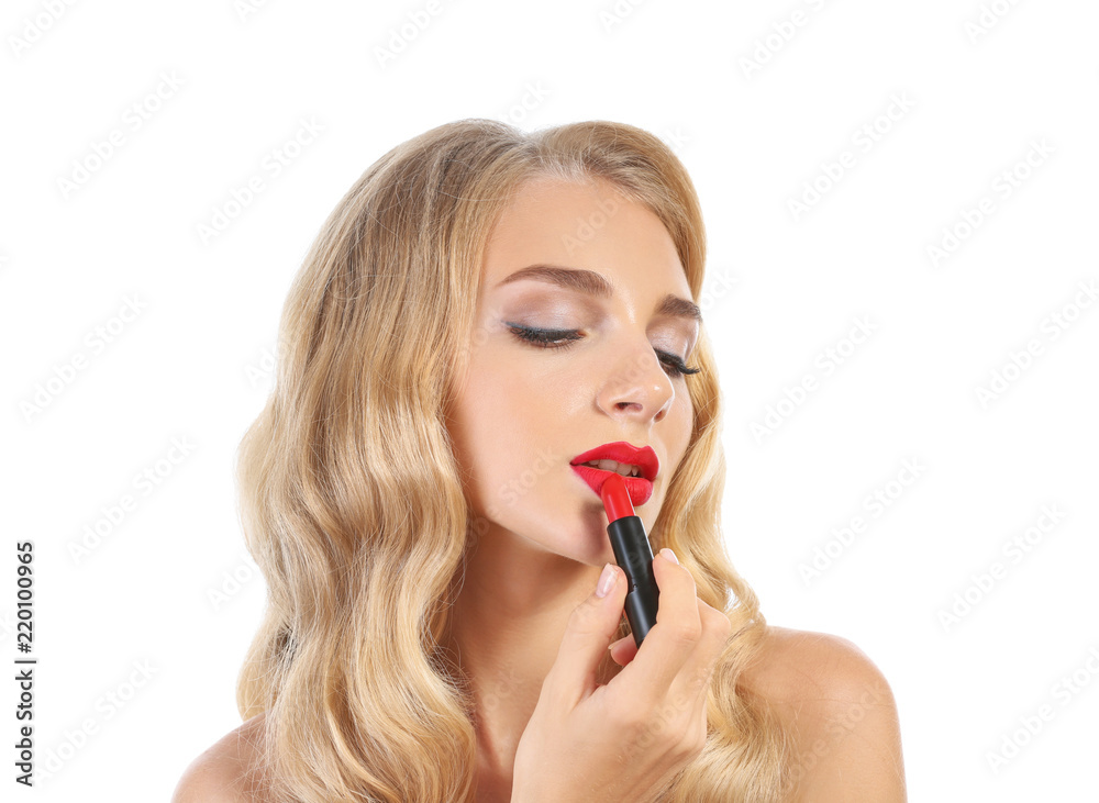 Beautiful young woman applying red lipstick on white background Beautiful young woman applying red lipstick on white background