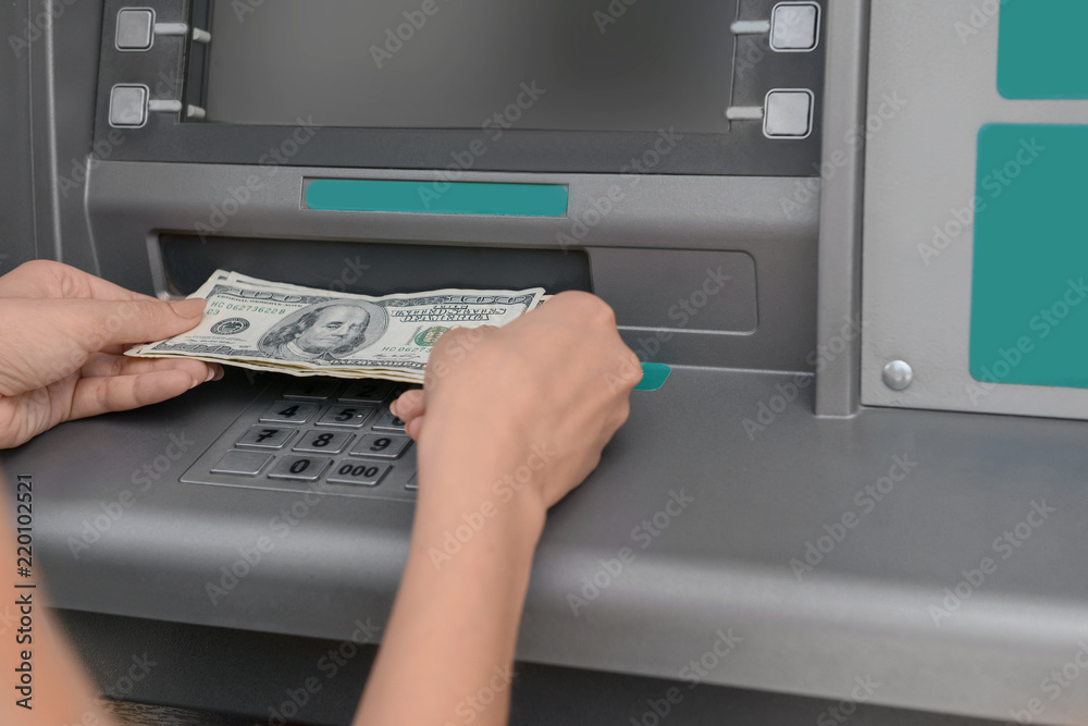 Woman picking up the money from a cash machine, closeup Woman picking up the money from a cash machine, closeup