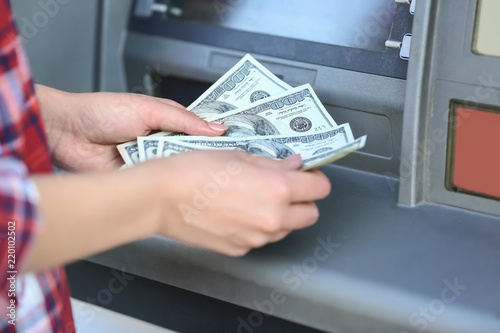 Woman with dollar banknotes near cash machine, closeup