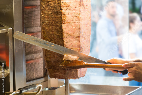 Cutting with doner knife traditional turkish Doner Kebab meat. Turkish cuisine street food in Istanbul, Turkey.