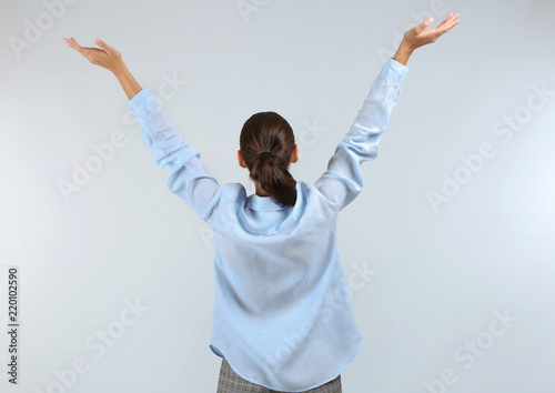 Happy young woman on light ...