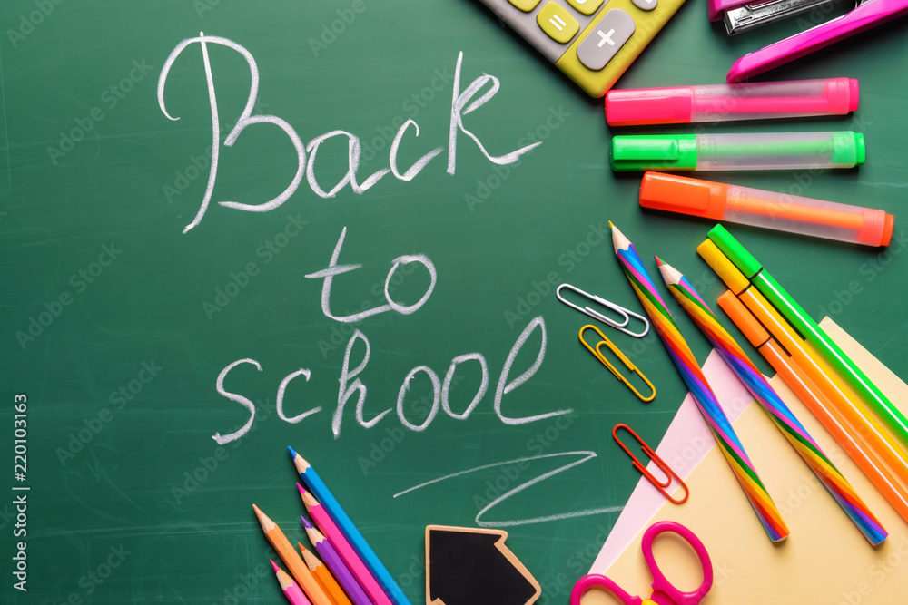 Stationery and words BACK TO SCHOOL written on chalkboard Stationery and words BACK TO SCHOOL written on chalkboard