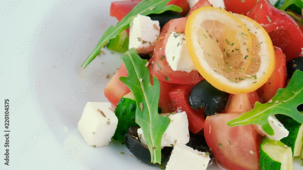 Classic Greek salad with feta cheese, vegetables, black olives and arugula, served in restaurant, close-up view, loop Classic Greek salad with feta cheese, vegetables, black olives and arugula, served in restaurant, close-up view, loop