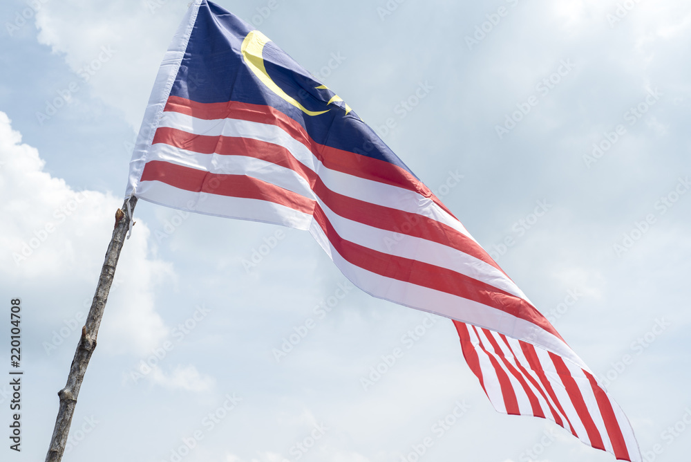 Obraz premium Malaysia flag also known as Jalur Gemilang wave with the blue sky. People fly the flag in conjunction with the Independence Day celebration or Merdeka Day.