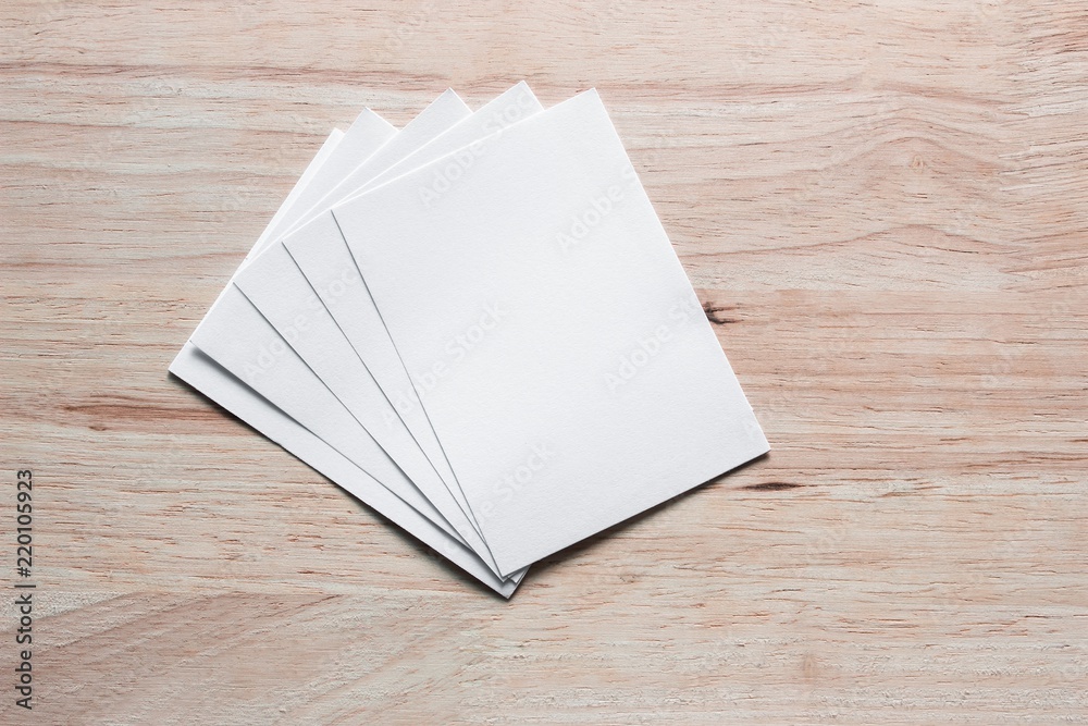Blank portrait mock-up paper. brochure magazine isolated on brown wooden table, changeable background / white paper isolated on wood Blank portrait mock-up paper. brochure magazine isolated on brown wooden table, changeable background / white paper isolated on wood
