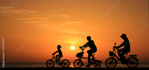 silhouette family  riding bicycle at sunset sky
