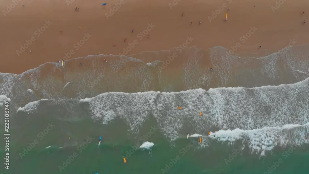 Aerial - surfers in an amazing and unspoiled beach learning to surf Aerial - surfers in an amazing and unspoiled beach learning to surf