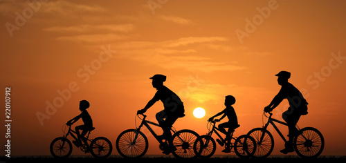 silhouette family  riding bicycle at sunset sky