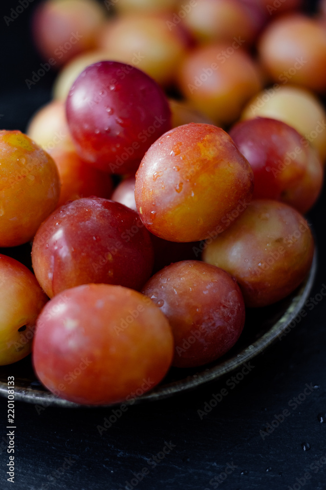 Ripe and beautiful wild plum fruits over black background.