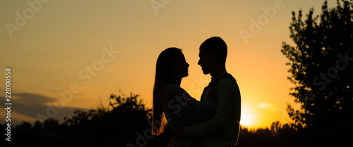 Silhouette couple kissing over sunset background, Profiles of romantic couple looking at each other on background of sunset