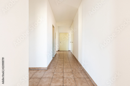 White corridor with tiles and closed doors