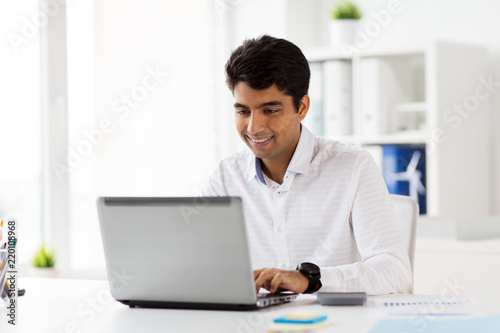 business, people, paperwork and technology concept - businessman with laptop computer and papers at office