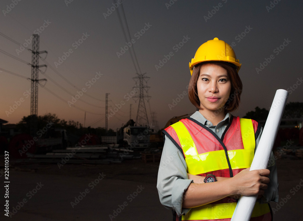 Asian engineer girl holding blueprint at construcktion site on twilight background,Asian women engineer portrait Asian engineer girl holding blueprint at construcktion site on twilight background,Asian women engineer portrait