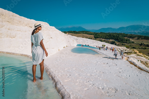 The enchanting pools of Pamukkale in Turkey. Pamukkale contains hot springs and travertines, terraces of carbonate minerals left by the flowing water. The site is a UNESCO World Heritage Site. photo