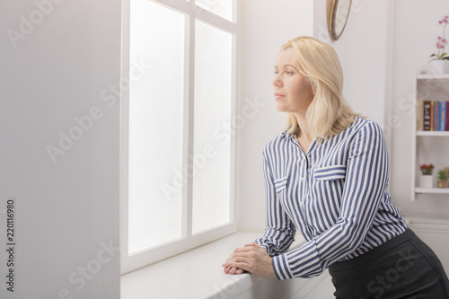 Woman standing near window at her office