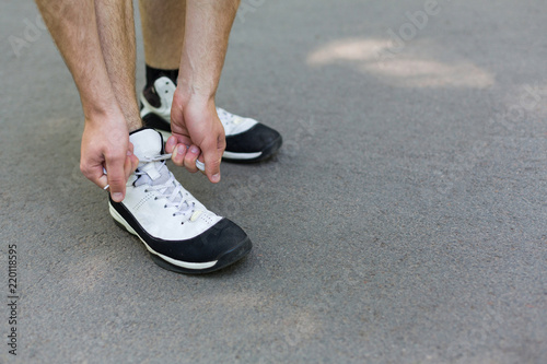 Unrecognizable man tying shoelaces before running