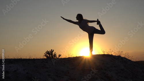 Silhouette young woman practicing yoga and Meditation at sunset © Chepko Danil