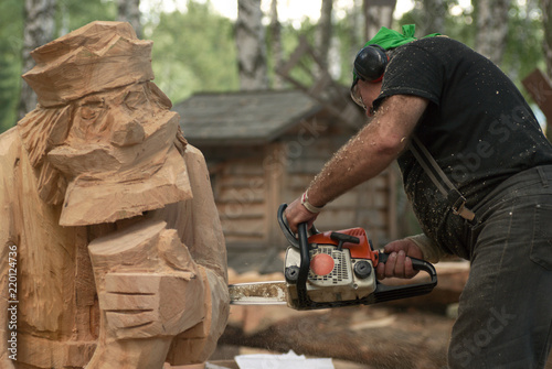 Woodcarver make his sculpture with chainsaw. Photo from a carpenter's contest.
