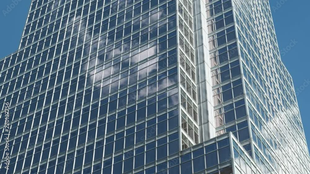 Pan of Modern Business Office Building with Clouds and Blue Sky Reflection on Glass. 4K Pan of Modern Business Office Building with Clouds and Blue Sky Reflection on Glass. 4K