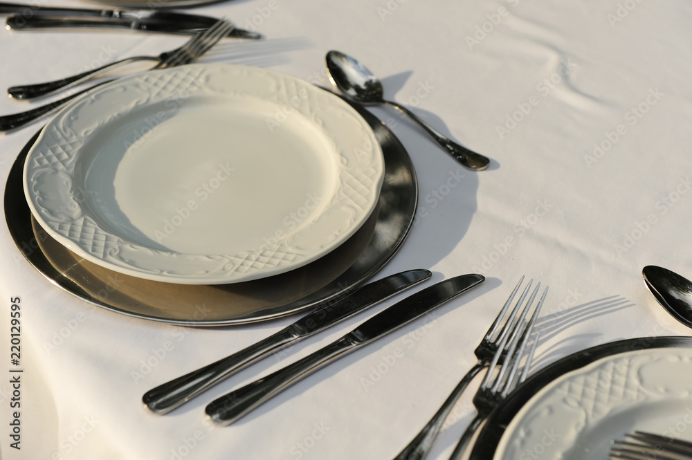 Platos y cubiertos, mesa preparada para un banquete en el exterior Stock  Photo | Adobe Stock