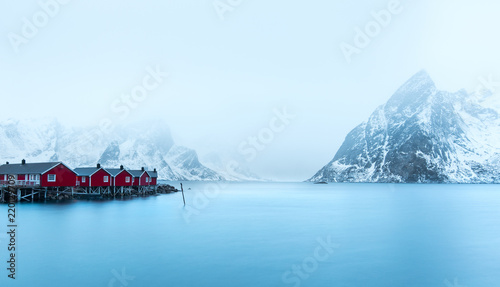 Blue water of sea with red cabins on shore
