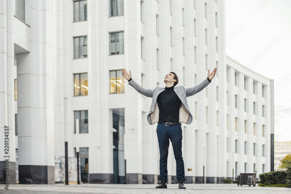 Distant plan of happy man raising his arms while going to or from work. Distant plan of happy man raising his arms while going to or from work.