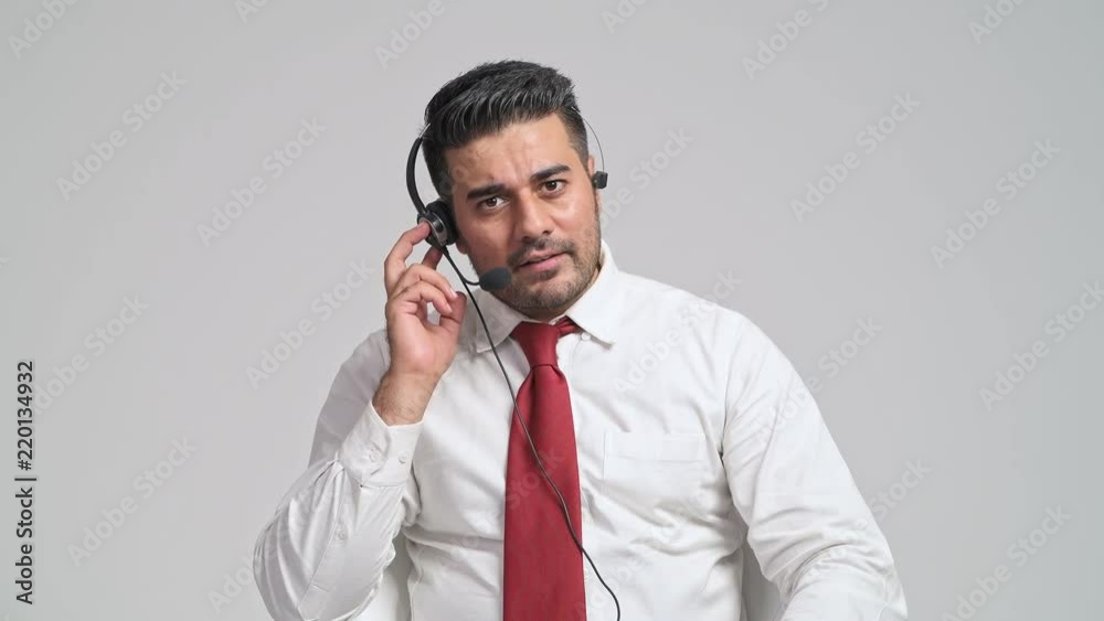 Customer service operator engaging with customer portrait. Young indian man with red tie and headphone, talking to customer in front of camera. Customer service call center concept. Customer service operator engaging with customer portrait. Young indian man with red tie and headphone, talking to customer in front of camera. Customer service call center concept.