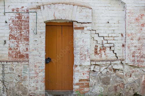Large brown wooden door on a white wall © nellino7