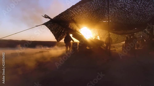 Soldiers fire heavy artillery in the battlefield. photo