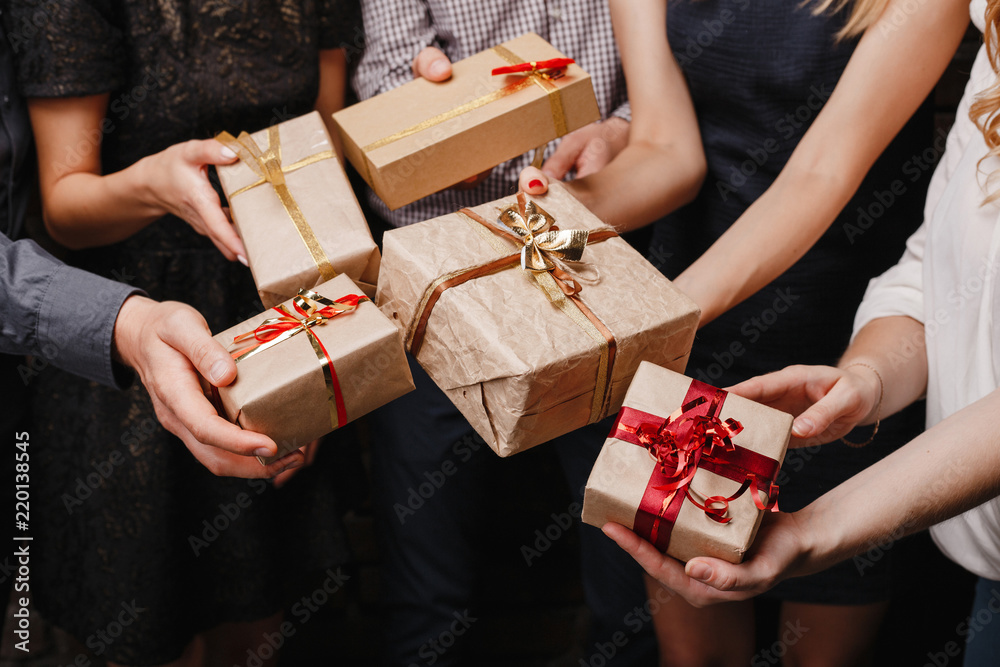Christmas party, New Year celebration, sale, black friday, holiday, fun, togetherness. Group of people with presents. Close up hands opening gift boxes